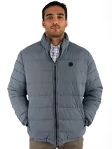 Campera puffer reversible color verde azulado con interior gris. Tiene cuello alto, cierre frontal y bolsillos laterales con cierre.