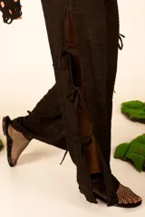 Pantalón negro de crepe con corte palazzo y lazos decorativos en los laterales.