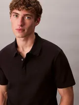 Chomba de manga corta Calvin Klein confeccionada en algodón interlock, con cuello clásico y cierre frontal de dos botones.