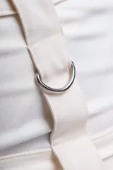 Minifalda negra con tres hileras de correas ajustables con hebillas plateadas.