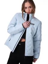 Campera matelaseada de mujer marca Caterpillar, color celeste, con cuello alto, cierre frontal central, bolsillos laterales con cremallera y parche con logo de la marca en el pecho.