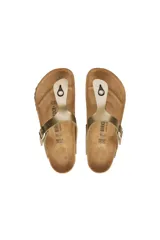 Sandalias Birkenstock Gizeh color dorado con tira delgada entre los dedos y hebilla lateral ajustable.
