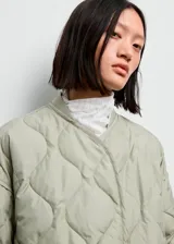 Campera acolchada de diseño oversize en color verde claro, con cuello redondo, cierre frontal de botones a presión y manga larga.