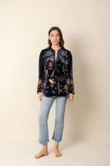 Blusa de terciopelo azul con bordados multicolores, cuello mao y botones forrados.