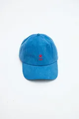 Gorra clásica de denim lavado azul con bordado rojo de una estrella y líneas en el frente, y visera curva.