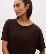 Remera de microfibra color marrón, con cuello redondo, mangas cortas y diseño holgado con aberturas laterales y ruedo redondeado.