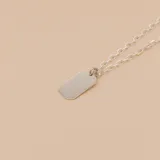 Dije de medalla rectangular con bordes redondeados, fabricado en plata 925, con superficie lisa apta para grabado.