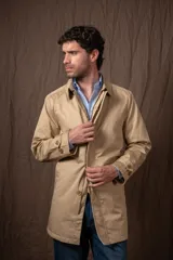 Trench color beige con cierre de botones y cuello clásico.