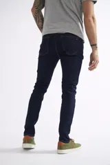 Jean de corte skinny para hombre, con diseño de cinco bolsillos, pasacintos y cierre frontal. Confeccionado en denim de tono azul claro con acabado lavado.