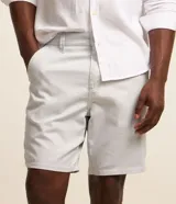 Bermuda básica masculina de sarga color gris, con trabillas en la cintura, cierre tradicional de botón y cremallera, y bolsillos funcionales.