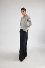 Pantalón de tiro medio con corte amplio y fluido, confeccionado en tencel. Presenta bolsillos delanteros y diseño con cortes curvos que aportan movimiento.