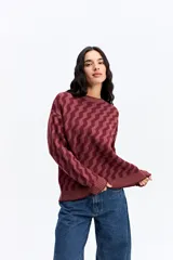 Buzo de punto con diseño geométrico en zigzag, de cuello redondo y manga larga. Presenta un calce holgado y cómodo con puños y ruedo acanalados.