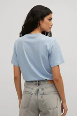Remera de algodón de manga corta con cuello redondo y estampado artístico en el pecho que representa figuras abstractas.