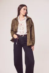 Sobrecamisa de gamuza sintética en color marrón chocolate, con corte oversize, cuello camisero, cierre frontal con botones y bolsillos frontales tipo parche.