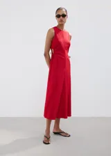 Vestido midi color rojo, sin mangas, con cuello redondo y aberturas laterales en la cintura con tiras ajustables.