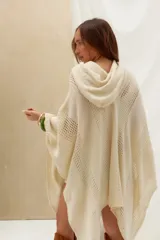 Poncho de tejido de punto color crudo, con capucha y diseño amplio.