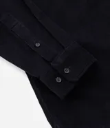 Camisa de hombre de corte regular confeccionada en terciopelo de algodón, con cuello clásico, cierre frontal de botones y dos bolsillos con solapa en el pecho.
