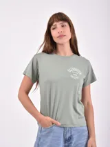 Remera de algodón color verde oliva, con cuello redondo, manga corta y estampado gráfico en el pecho con la frase 'Sunshine Stay Wild 1982 Smiling'.