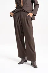 Pantalón sastrero de tiro alto con corte amplio y pinzas frontales. Presenta bolsillos laterales y cierre frontal con botón.