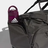 Bolso deportivo Adidas Training Defender de color gris oscuro con detalles en negro. Cuenta con un compartimento principal con cierre de doble dirección, correa ajustable y extraíble para el hombro, asas de mano y perforaciones láser para ventilación.