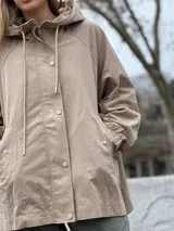 Campera de estilo casual color beige, con cierre frontal, botones a presión y puños elásticos.