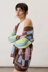 Saco abierto de punto con diseño geométrico de bloques en tonos marrón, celeste, lila y verde, con puños y ribetes acanalados.