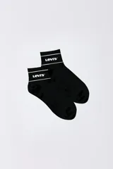 Medias cortas Levi's de color negro con franja blanca y logo de la marca en el puño.