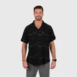 Camisa de manga corta con cuello cubano, confeccionada en viscosa con estampado sutil de camuflaje oscuro. Presenta cierre frontal con botones y un bolsillo pequeño en el pecho.