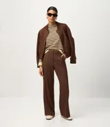 Sweater de punto de manga larga, con rayas horizontales en azul marino y blanco. Presenta cuello redondo ligeramente elevado y puños y ruedo en color blanco liso.