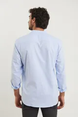 Camisa blanca de manga larga con cuello mao y bolsillo en el pecho.