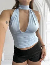 Top amarillo pálido con cuello halter y escote profundo. Se puede usar de múltiples formas.