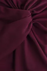 Pantalón de tiro alto color bordó, con corte holgado, piernas rectas y detalle drapeado con nudo girado en la parte frontal.