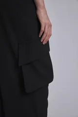 Pantalón cargo negro de corte ancho, con bolsillos laterales con fuelle y trabillas en la cintura.