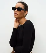 Vestido midi de punto acanalado en color marrón chocolate, con cuello barco y mangas largas. Presenta un corte ajustado al cuerpo y una textura de malla fina.