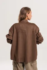 Sobrecamisa de estilo oversize confeccionada en material simil gamuza, con cuello clásico y diseño de corte recto.