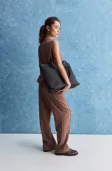 Pantalón de corte recto y holgado, color marrón, con costuras frontales verticales que estilizan la silueta.