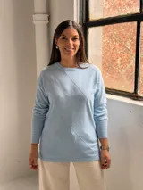 Sweater de punto color celeste con diseño de rombos en relieve en el frente, cuello redondo y mangas largas con puños ajustados.