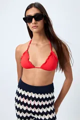 Top de bikini negro con tirantes finos y volados en el borde.