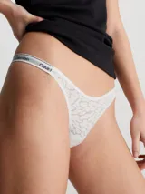 Colaless de tiro medio, color blanco, confeccionado en encaje semitransparente con patrón de leopardo. Presenta ribetes elásticos con el logotipo de Calvin Klein.