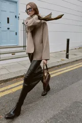 Bolso de hombro con diseño alargado y acabado efecto cuero envejecido. Cuenta con cierre principal de cremallera, interior organizado con tres compartimentos y un bolsillo adicional con cierre. Incluye asa de hombro fija con detalles metálicos.