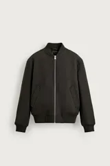 Cazadora bomber de corte regular fit en color negro, con interior de efecto pelo, cierre frontal de cremallera metálica, bolsillos de vivo en la cadera y acabados en rib elástico en cuello, puños y ruedo.