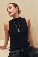 Top negro sin mangas, de cuello alto y tela texturizada.