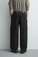 Pantalón cargo de corte relajado confeccionado en tejido de algodón con elasticidad. Presenta bolsillos laterales tipo cargo con solapa en las perneras, bolsillos frontales y bolsillos traseros de doble vivo. Cierre frontal con cremallera y botón.