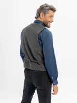 Chaleco de paño con escote en V, cierre frontal con botones y bolsillos tipo ojal. Presenta un diseño clásico de corte regular.