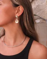 Gargantilla rígida de diseño minimalista, elaborada en metal dorado con acabado pulido, que se ajusta suavemente al cuello.