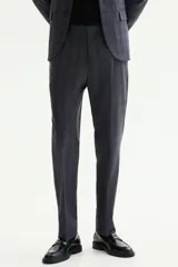 Pantalón de traje gris con sutil patrón a cuadros, corte slim fit con raya marcada en las piernas, bolsillos laterales y bolsillos traseros ribeteados.