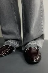 Mocasín de vestir negro con parte superior lisa y detalle de antifaz en el empeine, con suela a tono y ligero tacón.