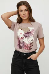 Remera de algodón de manga corta con cuello redondo, presenta un estampado floral frontal con detalles en lentejuelas brillantes.