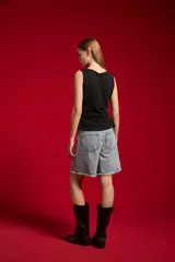 Musculosa blanca sin mangas de poliéster, con cuello bote y diseño ajustado al cuerpo.