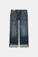 Jeans de mezclilla de tiro bajo y corte recto, con diseño de cinco bolsillos, trabillas para cinturón y dobladillo con vuelta ancha. Presenta un lavado azul medio con efecto desgastado.